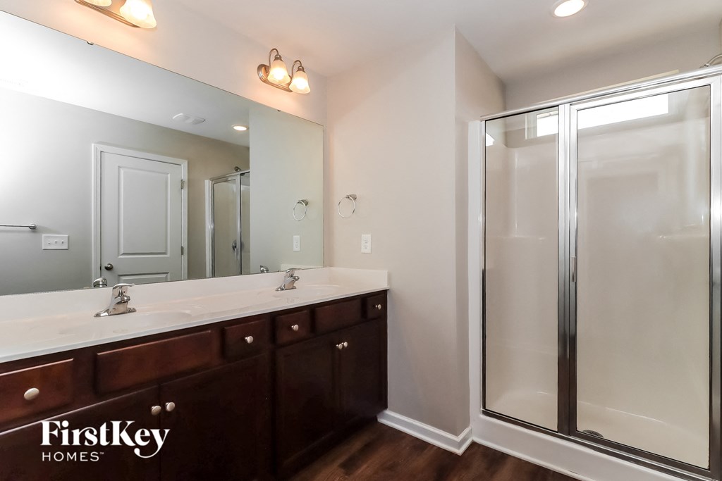 a bathroom with a shower and two sinks and a mirror