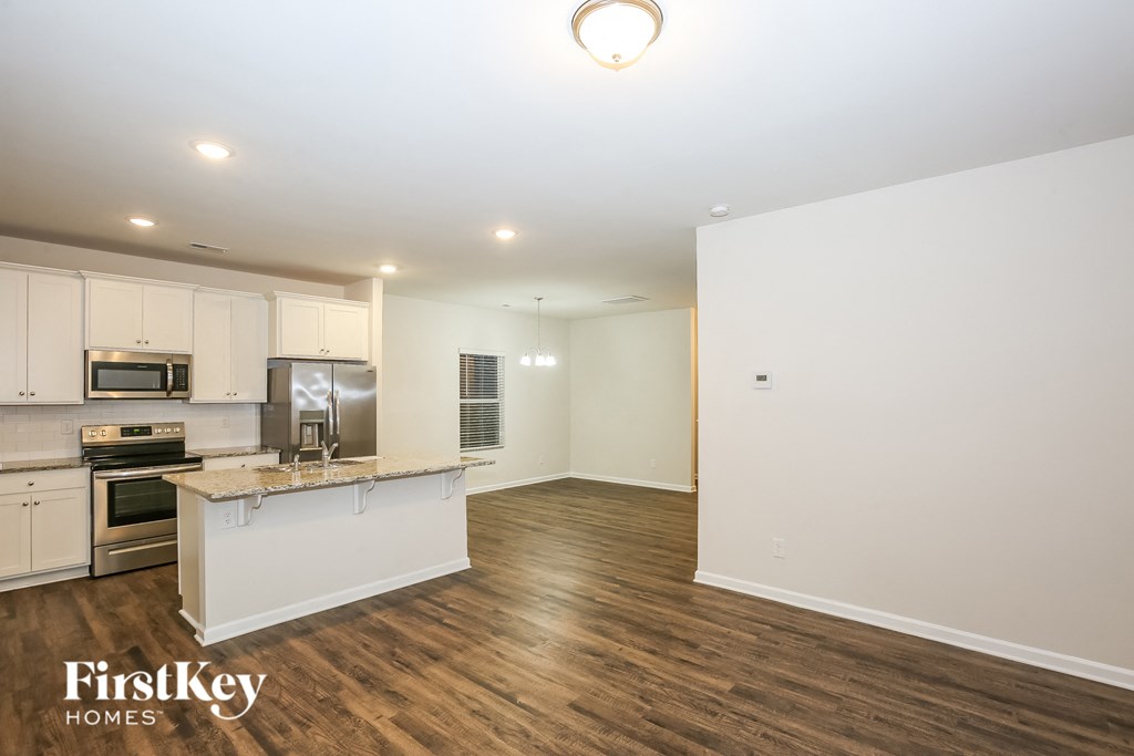 A kitchen with a white counter top and a microwave on it.