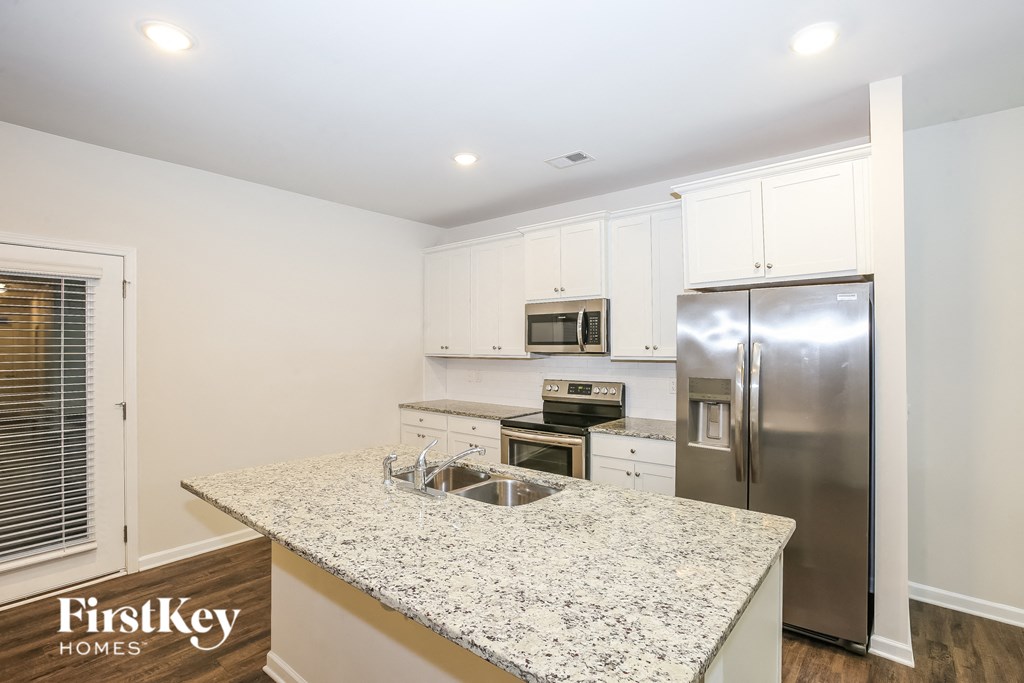 A kitchen with granite countertops and stainless steel appliances.