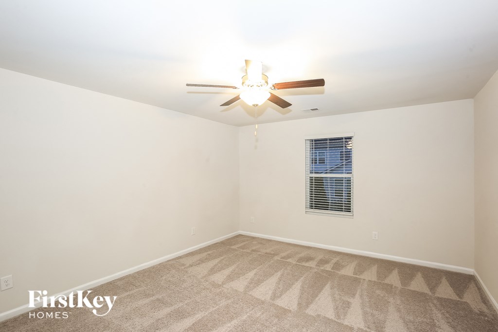 A room with a fan and a window.