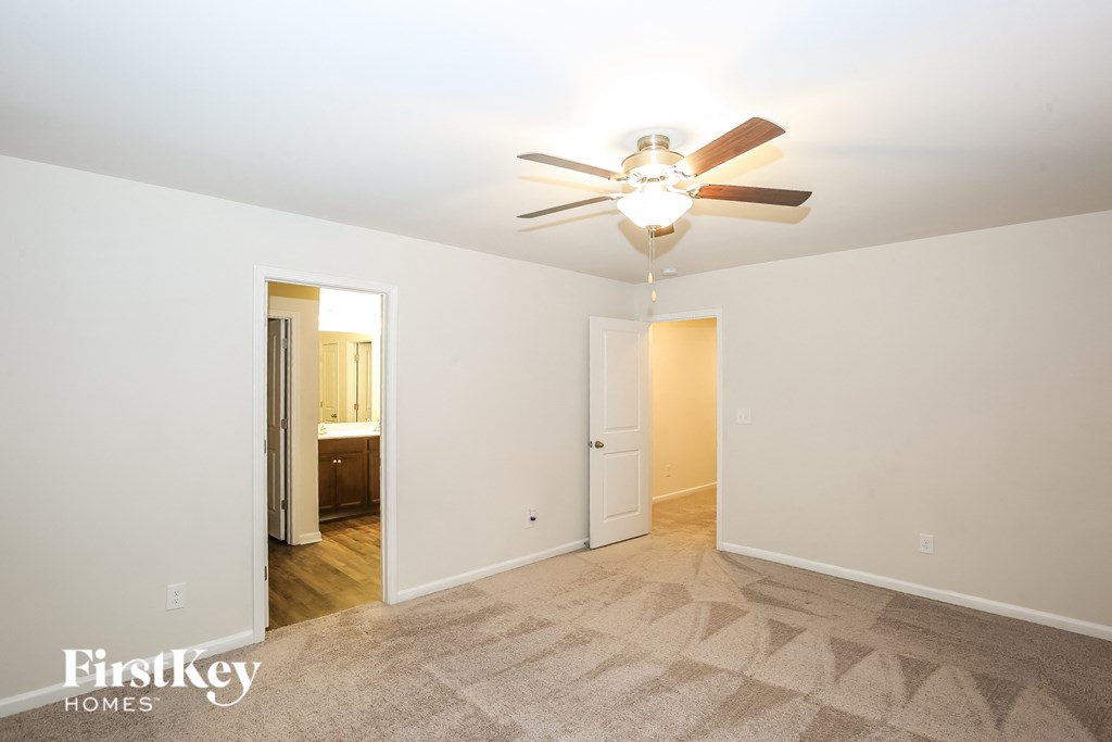 A room with a fan and a carpet.