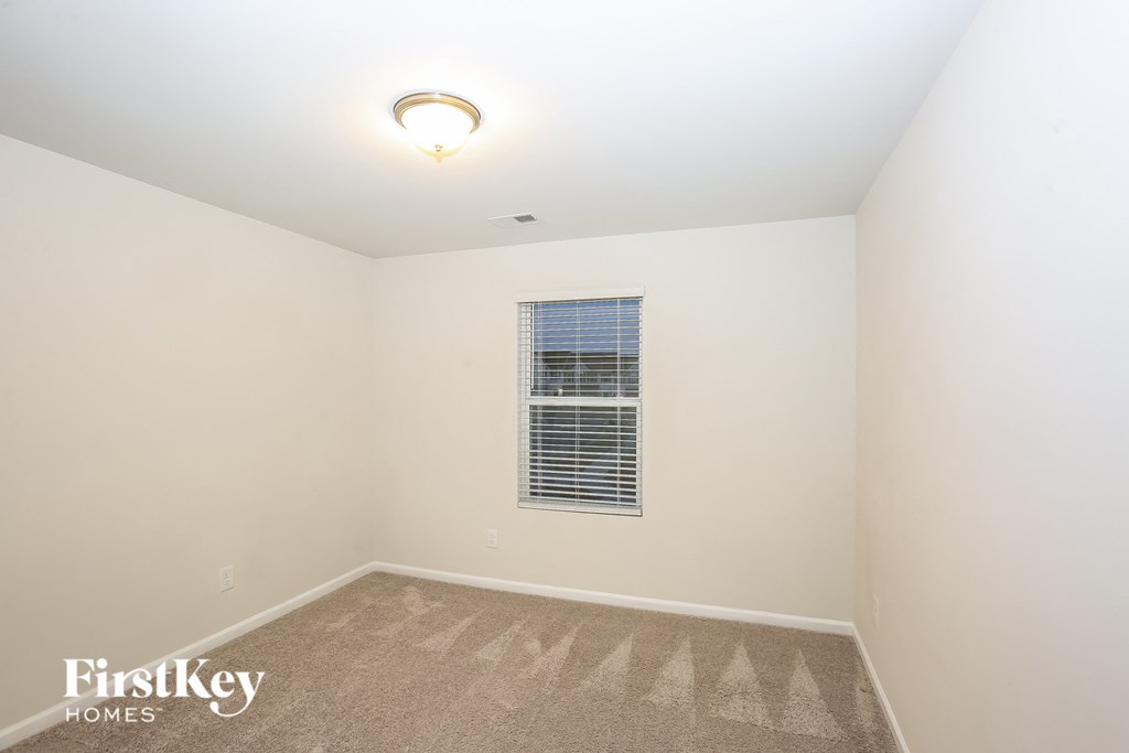 A room with a carpet and a window.
