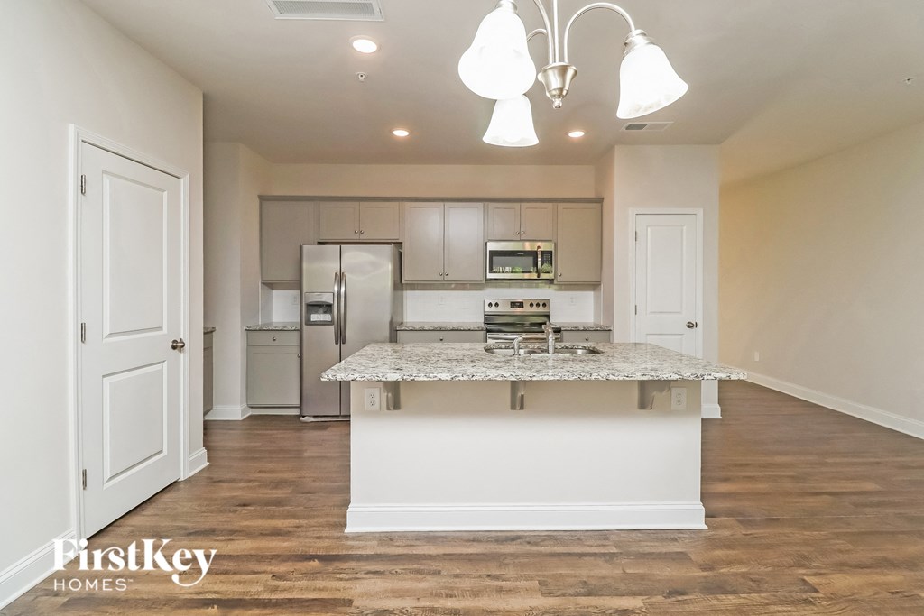A kitchen with a white island and a fridge.