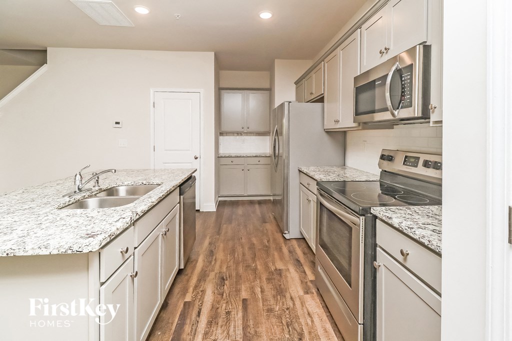 A kitchen with wooden floors and stainless steel appliances.
