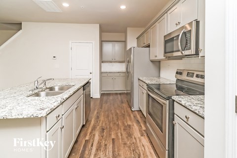 A kitchen with wooden floors and stainless steel appliances.