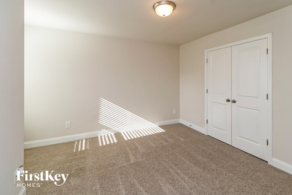 A room with a carpeted floor and a white door.