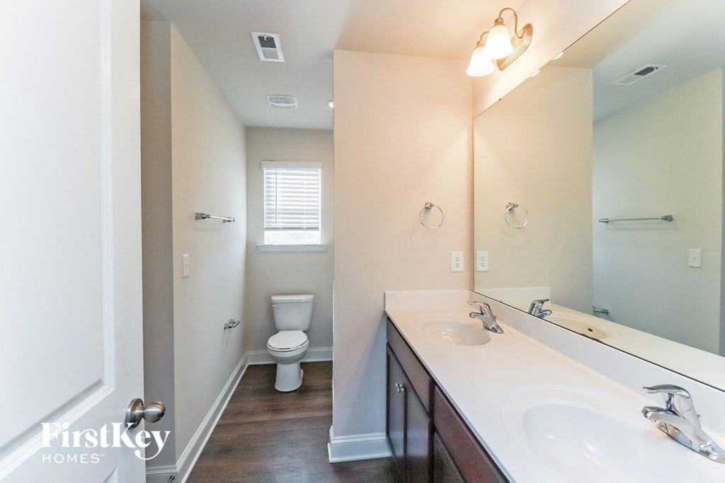 A bathroom with a white sink and a toilet.