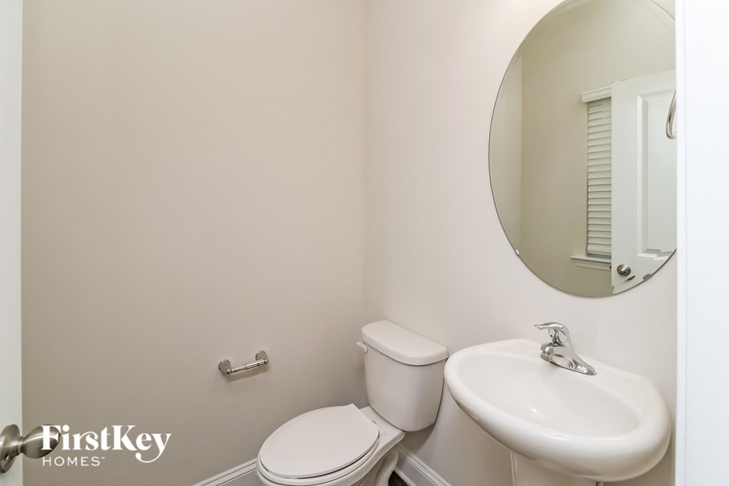 A white toilet and sink in a small bathroom.