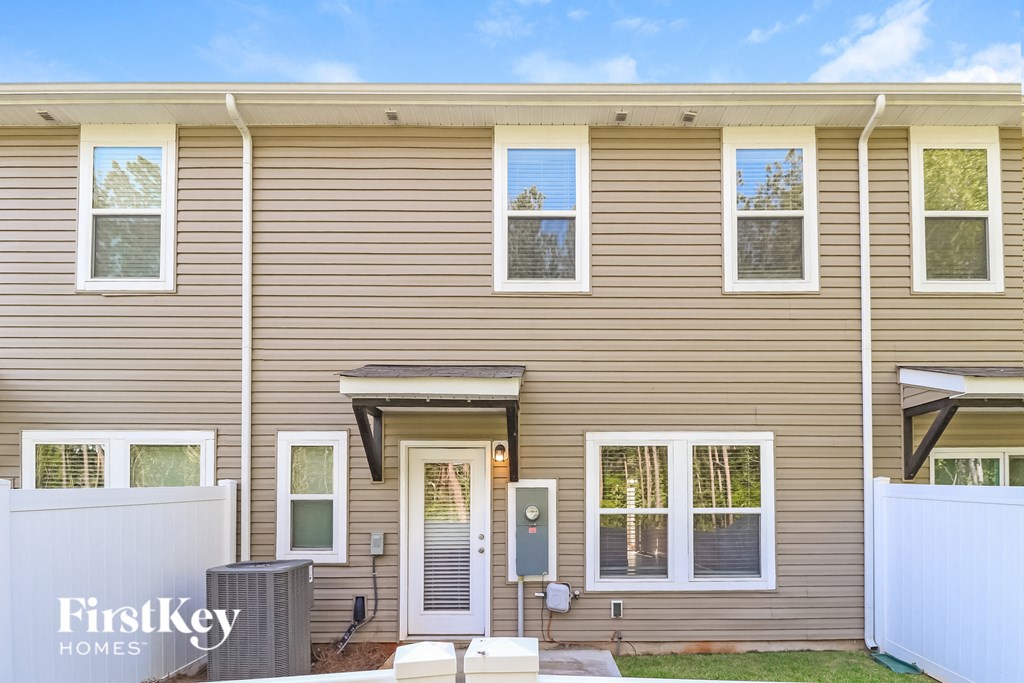 A beige house with the words "FirstKey Homes" on the fence.
