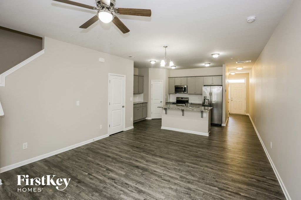 A spacious room with a kitchen area in the background.