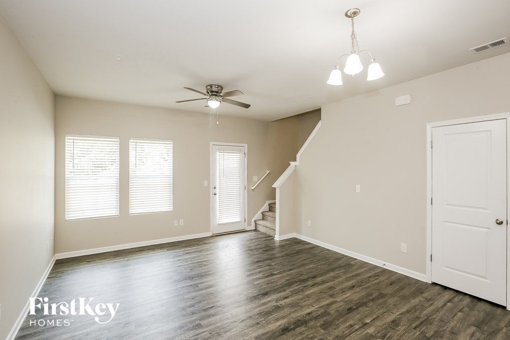 A spacious room with a staircase leading to the second floor.