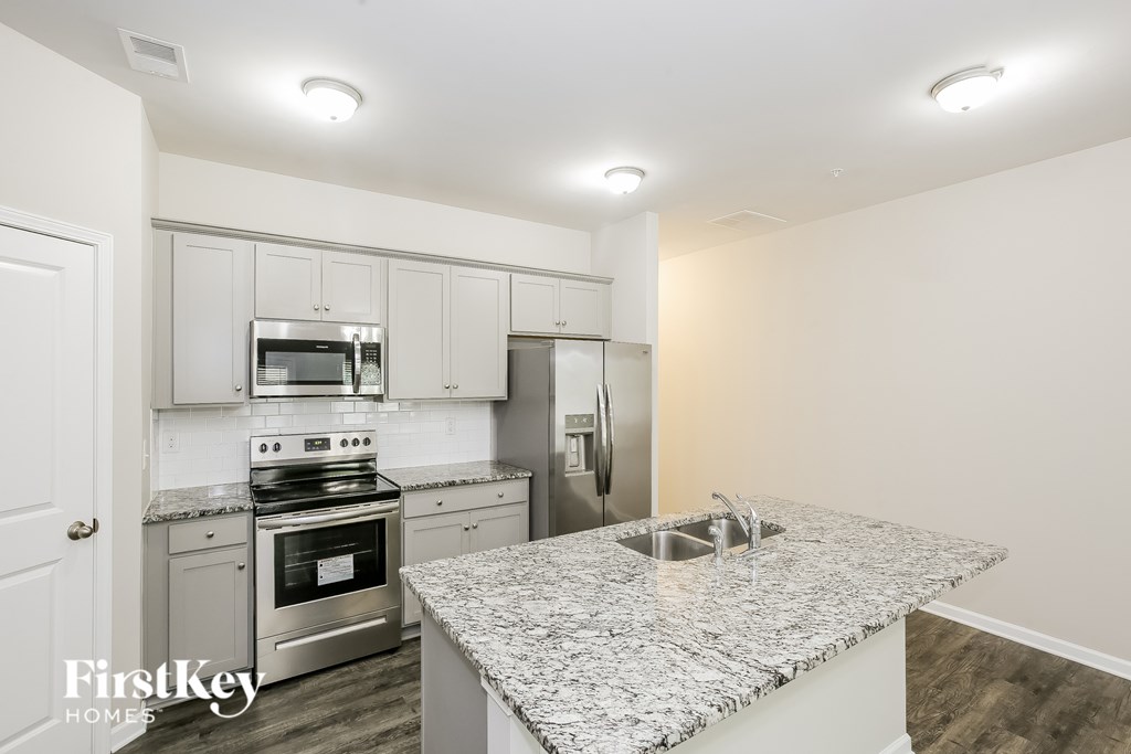 A kitchen with granite countertops and stainless steel appliances.