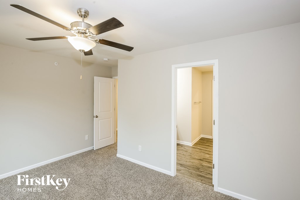 A room with a ceiling fan and two doors.