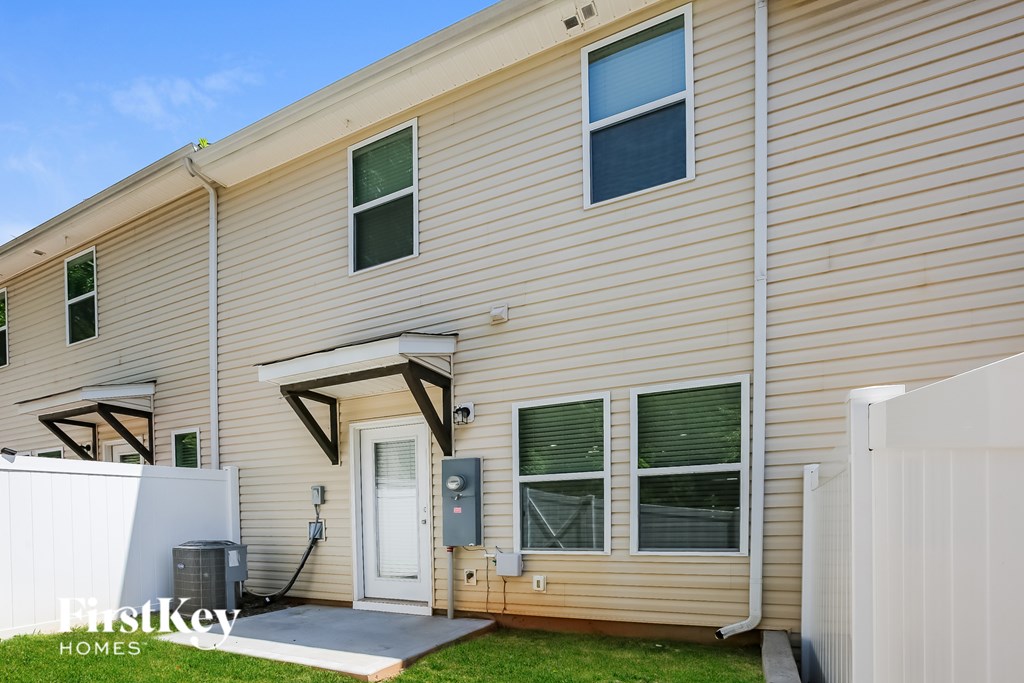 A beige house with a white door and a small porch.