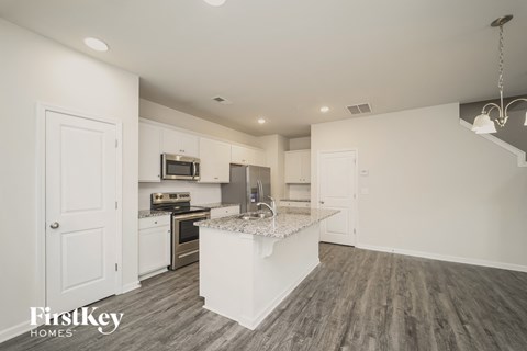 a renovated kitchen with white cabinets and a marble counter top
