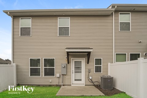 the exterior of a home with tan siding and a white door