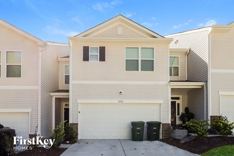 a white house with a garage door and a driveway