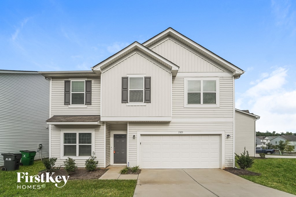a white house with white siding and a driveway
