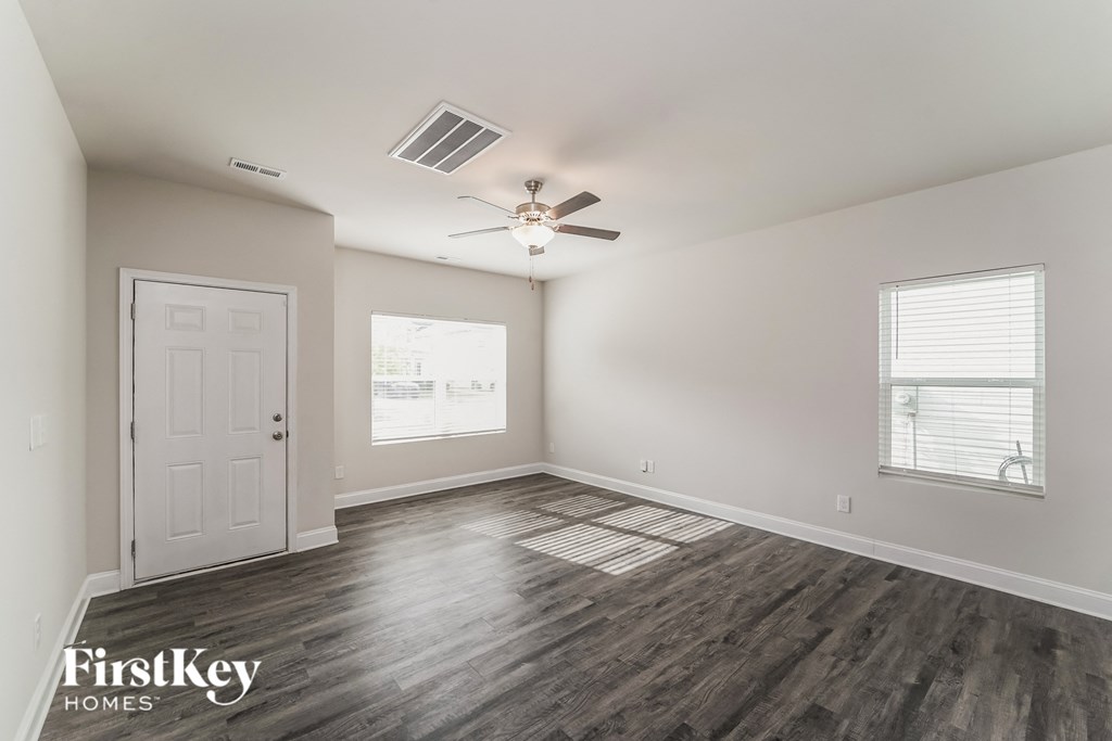 a living room with a ceiling fan and a white door