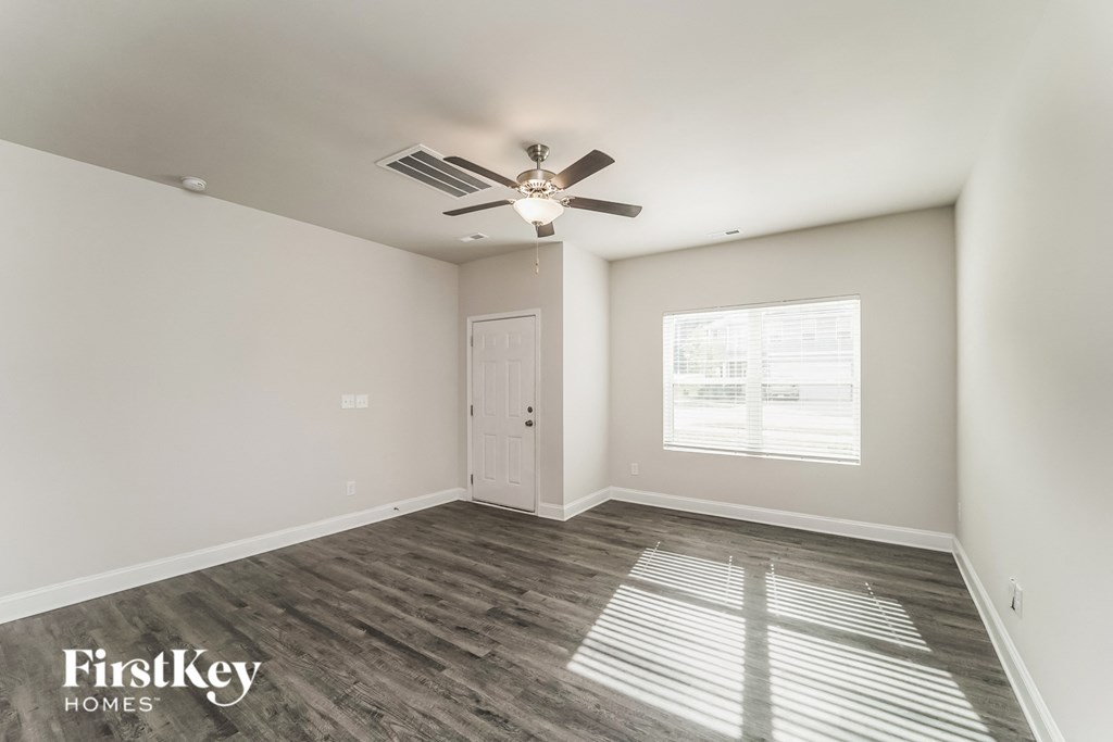a living room with a ceiling fan and a window