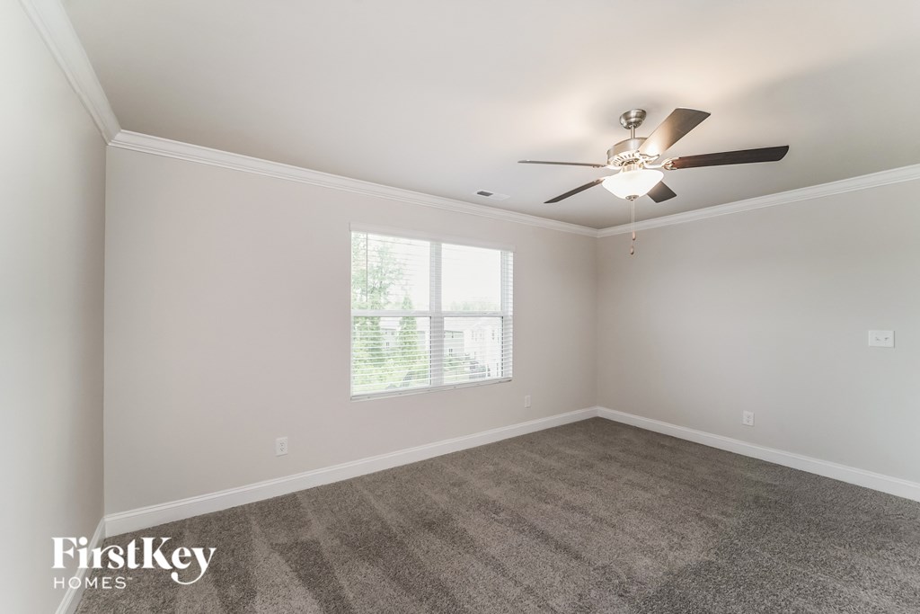 a living room with carpet and a ceiling fan
