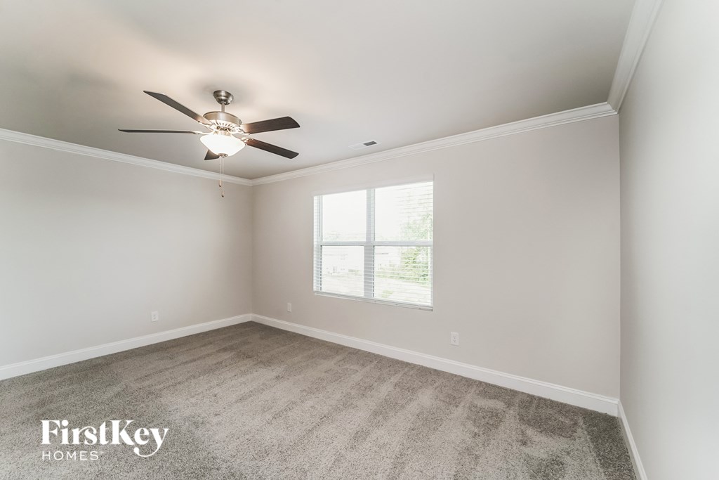 a bedroom with a ceiling fan and a window