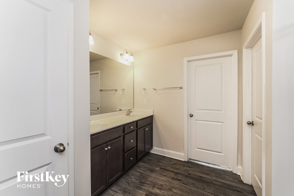a black and white bathroom with a sink and mirror