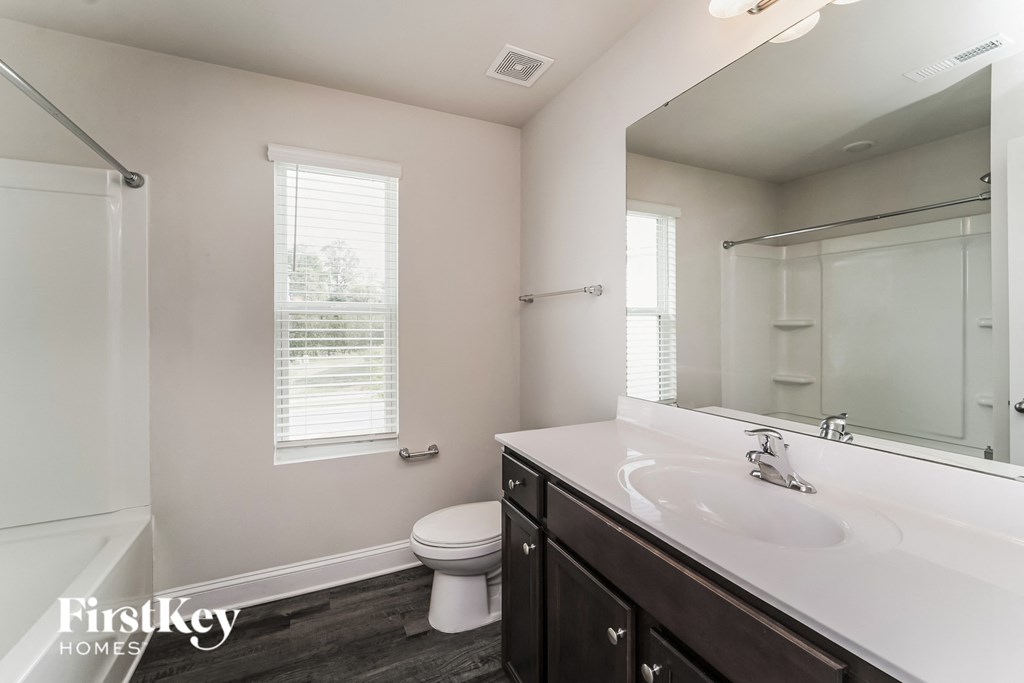 a bathroom with a large mirror and a sink and a toilet