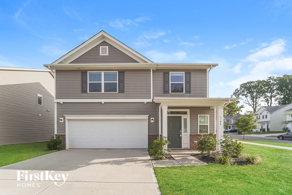 a house with a garage door and a lawn