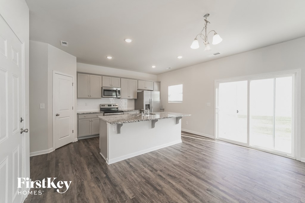 a white kitchen with a counter top and a large window