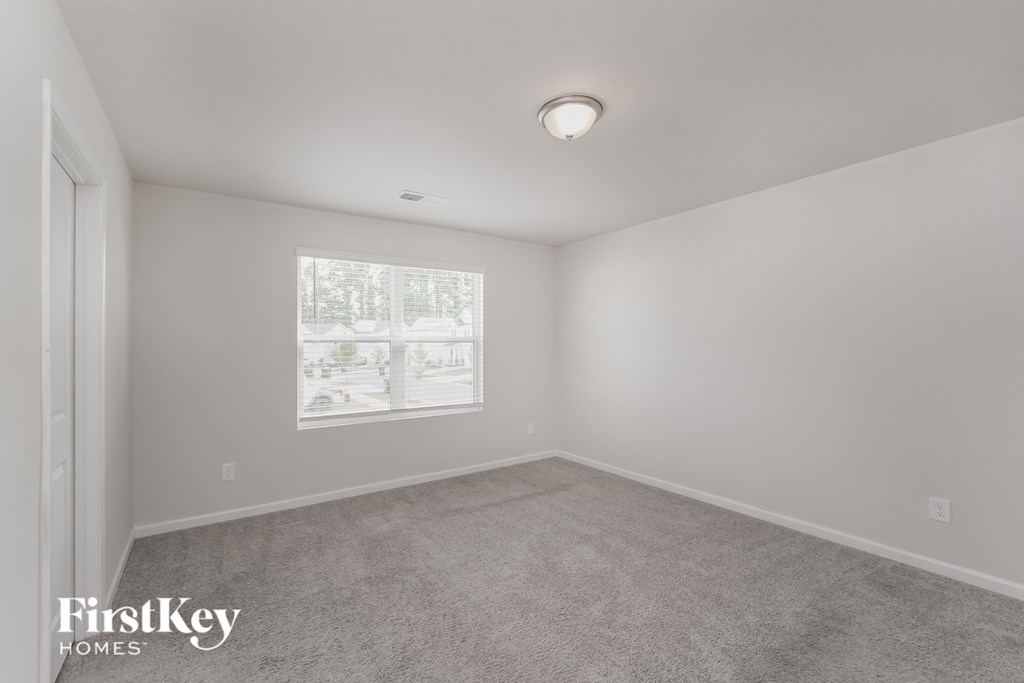 a bedroom with carpet and a window