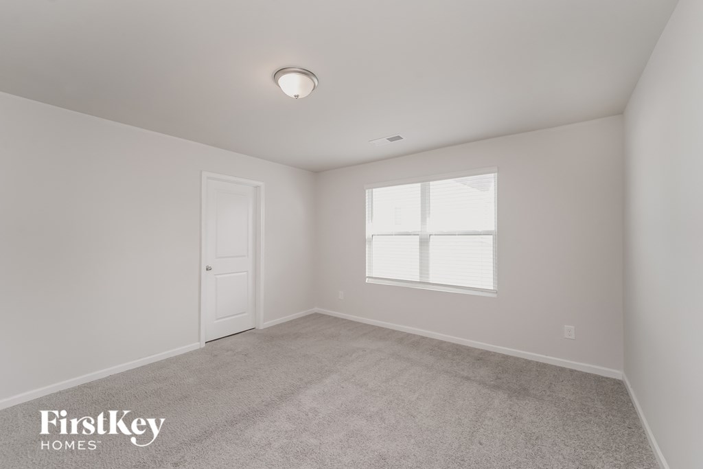 a bedroom with white walls and a white door and window