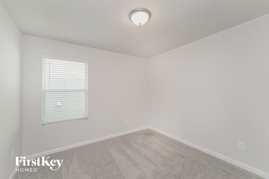 a bedroom with a carpeted floor and a window