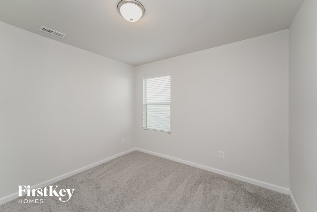 an empty room with white walls and a window