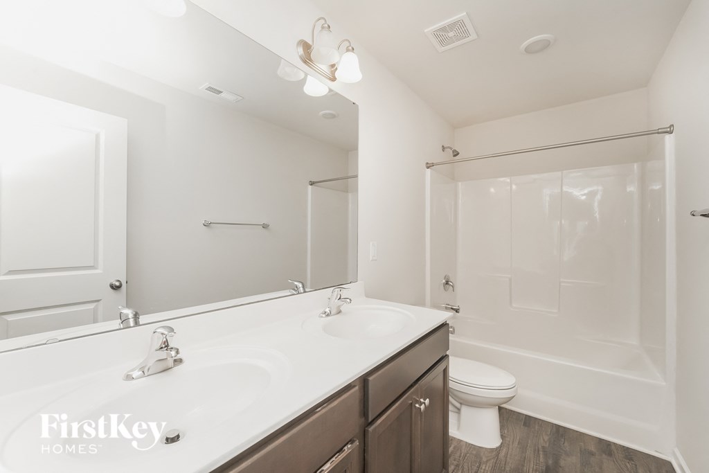 a bathroom with a large mirror and a toilet and a sink