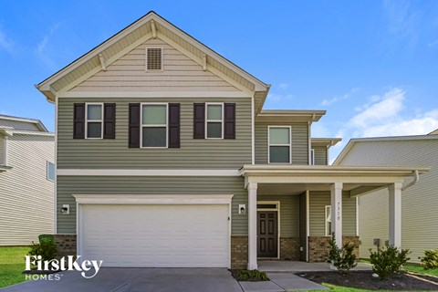 A two-story house with a garage is for sale.