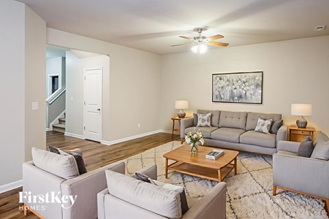 A living room with a grey couch, a coffee table, and a painting on the wall.