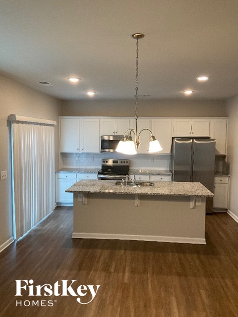 A kitchen with a granite countertop and stainless steel appliances.