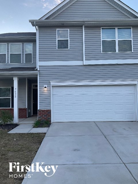 A grey house with a white garage door in front.