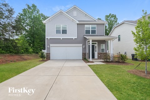 a blue house with a white garage door and a driveway