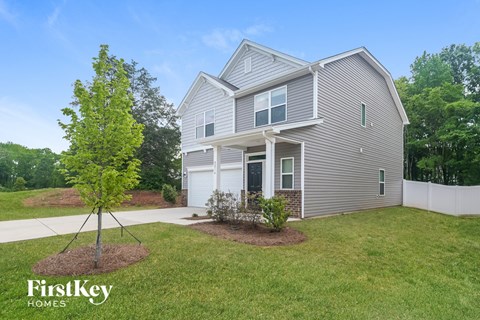 a house with a lawn and a tree in front of it