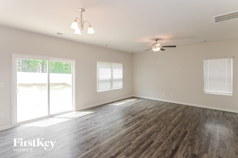 a living room with wood floors and a ceiling fan