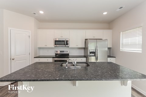 a kitchen with white cabinets and a granite counter top