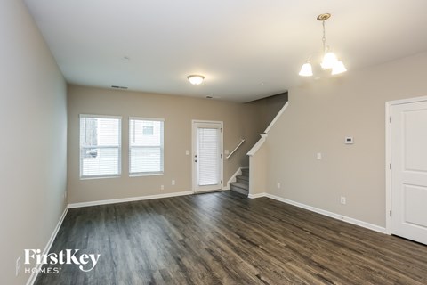 the living room and dining room of an empty house with wood flooring