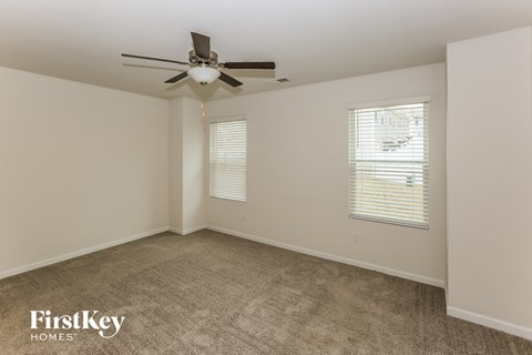 a living room with carpet and a ceiling fan