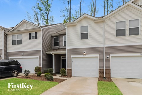 A house with a car parked in front and the words "FirstKey Homes" on the bottom left.