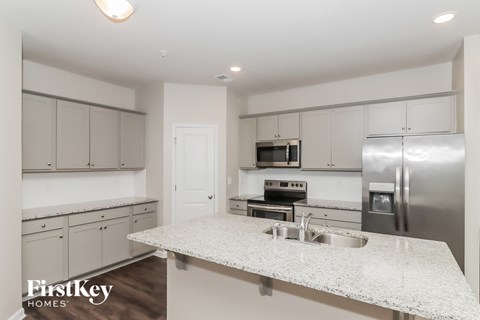 A kitchen with a granite countertop and stainless steel appliances.