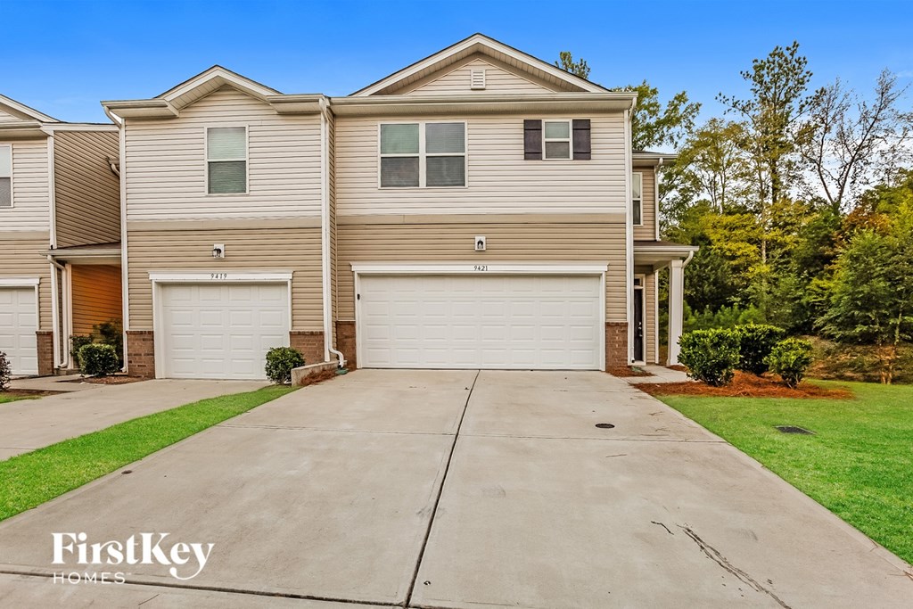 A large, two-story house with a garage is for sale.