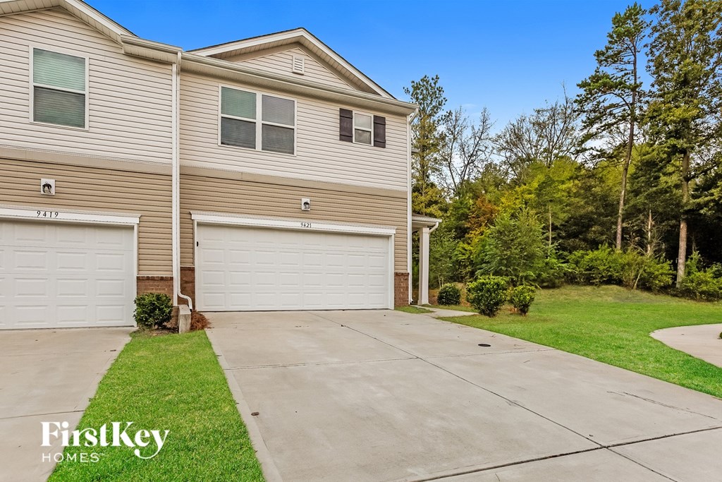 A two-story house with a garage is for sale.