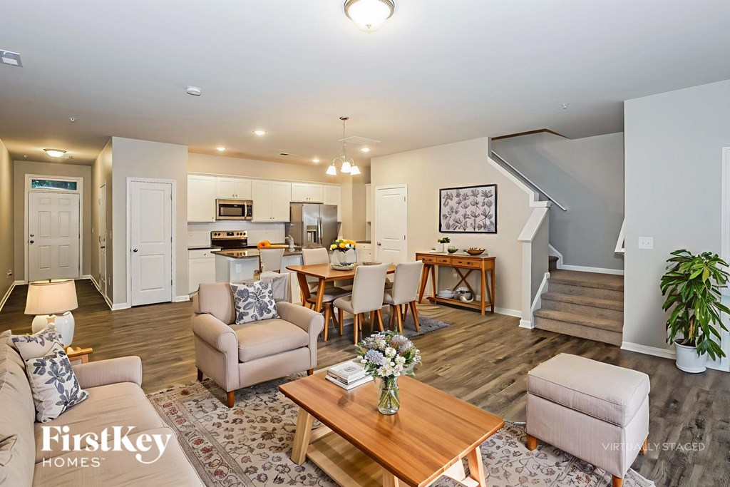 A well-lit living room with a dining area and a staircase.